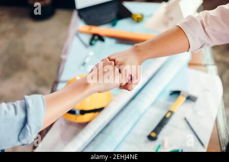 Ingenieur- und Architektpartner geben nach Abschluss des Abschlusses eine Faustfalle. Stockfoto