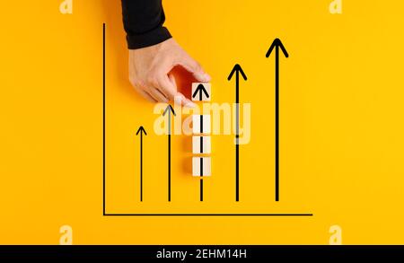 Männliche Hand zeichnet ein Geschäftsliniendiagramm oder Diagramm mit nach oben zeigenden Pfeilen. Konzept für das Aktienmarkt- oder Wirtschaftswachstum. Stockfoto