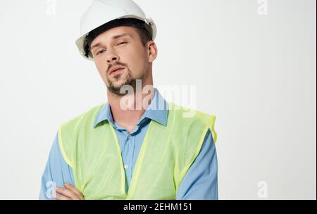 Bauarbeiter in weißem Helm und grünen reflektierenden Weste