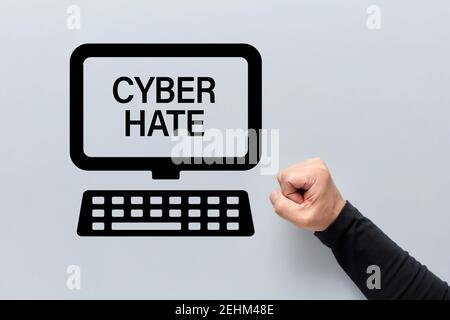 Männliche Faust mit einem Computer-Symbol mit Cyber-Hass auf dem Bildschirm geschrieben. Belästigung, Rassismus, Einschüchterung und Demütigung im Cyberraum. Stockfoto