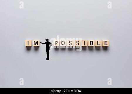 Silhouette eines von Hand gezeichneten Menschen Umwandlung des Wortes unmöglich in möglich durch das Verdrängen der Buchstaben. Aspiration, Positivität, Glaube, Motivation Stockfoto