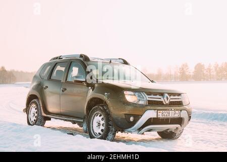 Gomel, Weißrussland. Auto Renault Duster Oder Dacia Duster Suv Geparkt Auf Winter Snowy Feld Bei Sonnenuntergang Dawn Sonnenaufgang. Stockfoto