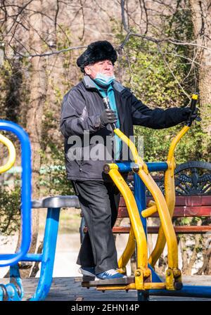 Bukarest, Rumänien -02,12.2021: Senior Mann beim Training auf einem Crosstrainer im Cismigiu Park, Bukarest. Stockfoto