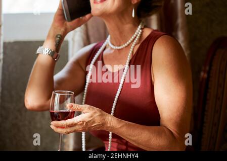 Frau trinkt und telefoniert Stockfoto