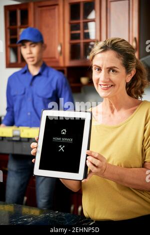 Frau, die App für den Home-Service verwendet Stockfoto