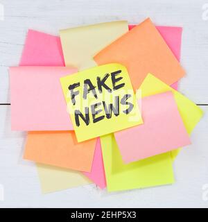 Fake News Wahrheit Lüge Medien Internet online Business Konzept Schreibtisch Notizpapier Notizpapier Stockfoto