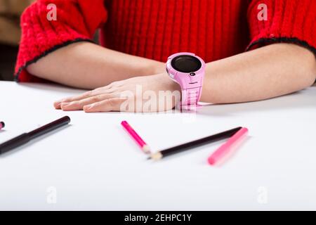 Kleines Mädchen trägt intelligente Uhr während der Zeit in der Schule. Stockfoto