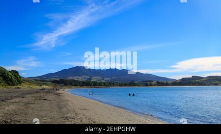 TE Kopua Beach, ein langer schwarzer Sandstrand in Raglan, Neuseeland. Am Horizont ist der Berg Karioi Stockfoto