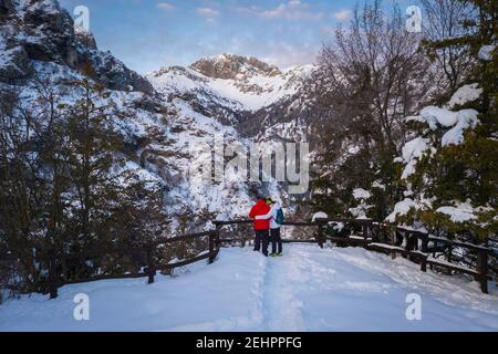 Zwei Menschen bewundern die Presolana im Winter von der Kirche San Peder. Rusio, Castione della Presolana, Val Seriana, Bezirk Bergamo, Lombardei, Italien. Stockfoto