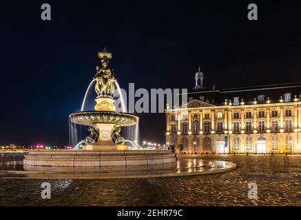 Brunnen von drei Gnaden auf dem Place de la Bourse in Bordeaux bei Nacht in Gironde, Nouvelle-Aquitaine, Frankreich Stockfoto