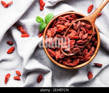 Trockene rote Goji-Beeren für eine gesunde Ernährung auf einem Fabric-Hintergrund Stockfoto