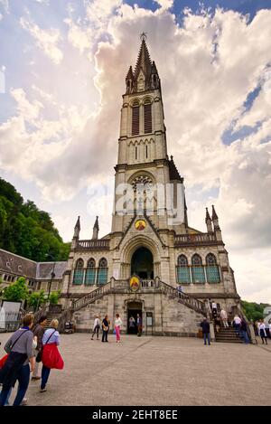 Lourdes, Frankreich - 05 2018. Christliches Kreuz auf einem Hintergrund die Basilika unserer Lieben Frau vom Rosenkranz in Lourdes, Frankreich Stockfoto