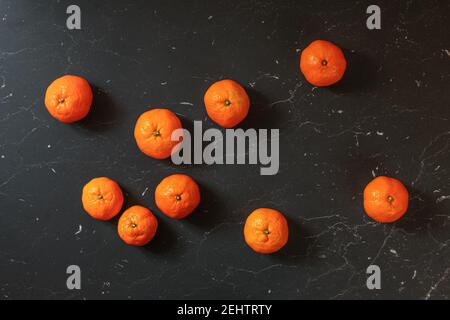 Draufsicht, Mandarinen-Mandarinen auf schwarzem Marmorbrett Stockfoto