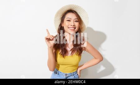 Junge schöne Frau trägt Sommerhut zeigt mit Handfinger Zur Seite mit Werbung Stockfoto