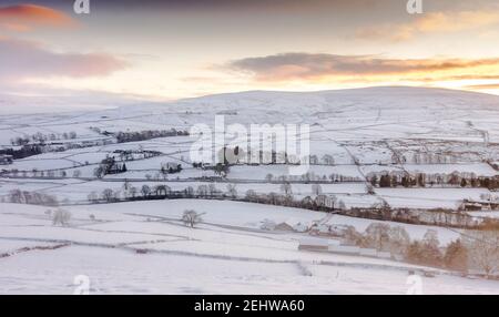 Ein Blick auf die schneebedeckten North Pennines an einem trüben, goldenen, späten Nachmittag, in Weardale, County Durham Stockfoto