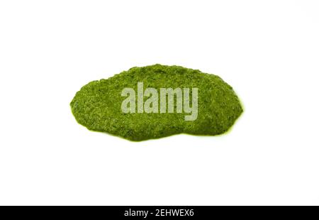 Pesto verbreiten oder Blob in einer Schüssel isoliert auf weißem Hintergrund. Grüne italienische hausgemachte verschüttete Sauce aus gemahlenem Basilikum, Knoblauch, Pinienkernen, Oliven. Stockfoto