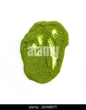 Pesto verbreiten oder Blob in einer Schüssel isoliert auf weißem Hintergrund. Grüne italienische hausgemachte verschüttete Sauce aus gemahlenem Basilikum, Knoblauch, Pinienkernen, Oliven. Stockfoto