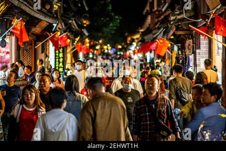 Dali China , 5. Oktober 2020 : Menschenmenge von Chinesen in Dali Altstadt in der Nacht mit Mann trägt Gesichtsmaske während 2020 goldene Woche in Dali Yunnan Chin Stockfoto