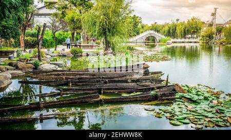 Dali China , 6 Oktober 2020 : Dali Xizhou Altstadt mit alten kleinen Booten Steinbrücke und Wasserteich in Xizhou Yunnan China Stockfoto