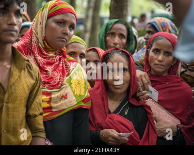 Cox‘s Bazar, Bangladesch. 08-27-2017. Frauen warten auf Nahrung und Vorräte, um ihre Häuser wieder aufzubauen, nachdem der Zyklonsturm Mora Verwüstungen und verursacht hat Stockfoto