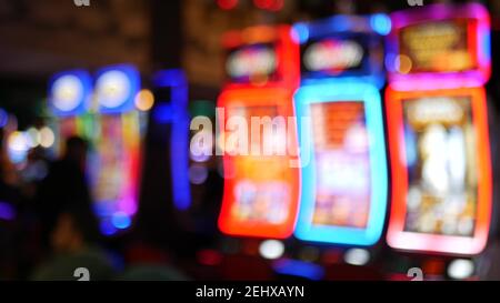 Unschärfe-Spielautomaten leuchten im Casino auf dem fabelhaften Las Vegas Strip, USA. Verschwommene Jackpot-Spielautomaten im Hotel in der Nähe der Fremont Street. Leuchtendes Neon Stockfoto