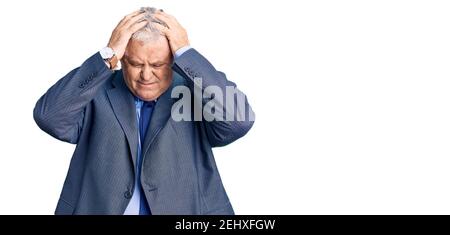Senior grauhaarige Mann trägt Business Jacke leiden unter Kopfschmerzen verzweifelt und gestresst, weil Schmerzen und Migräne. Hände auf dem Kopf. Stockfoto