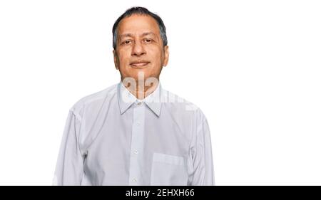 Mittelalter indischer Mann trägt lässiges weißes Hemd mit ernsthaftem Ausdruck im Gesicht. Einfach und natürlich auf die Kamera schauen. Stockfoto