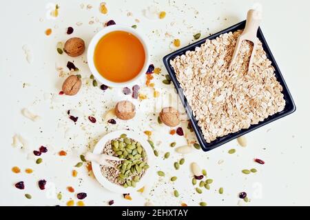 Konzept der Schalen voll Samen, Getreide und Honig auf weißem Hintergrund, obere Tabelle Stockfoto