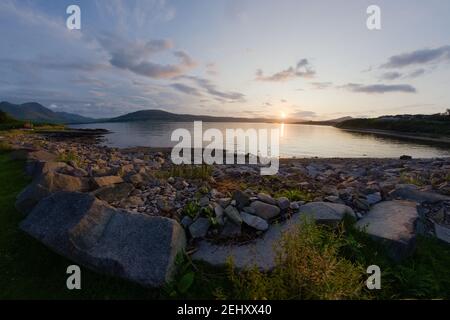 Ein Felsbrocken Meer Ufer bei Sonnenuntergang. Blick nach Westen in der Nähe von Ost-Suisnish auf der Insel Raasay, Insel skye in der Ferne. Eine Fischperspektive. Stockfoto