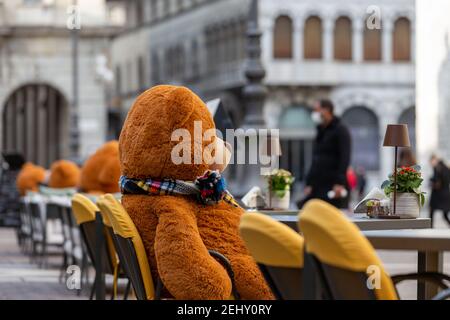 Plüsch-Spielzeug-Bären sitzen auf der Bank der Bar auf Italienisch Quadratisch Stockfoto