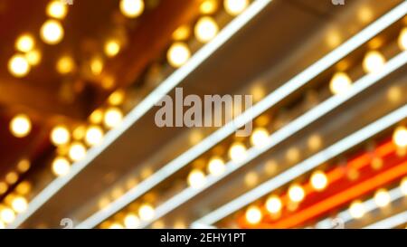 Defokussierte alte angefaste elektrische Lampen leuchten in der Nacht. Abstrakte Nahaufnahme von verschwommener Retro-Casino-Dekoration schimmernd, Las Vegas USA. Beleuchtetes vi Stockfoto