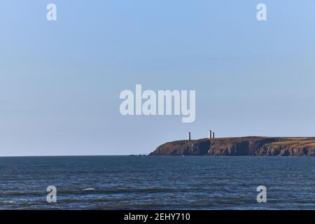 Monument auf Klippe, Fernsicht mit Meer und klarem Himmel mit Kopierraum. Metallmann in Tramore. Waterford. Irland. Horizontales Format. Stockfoto