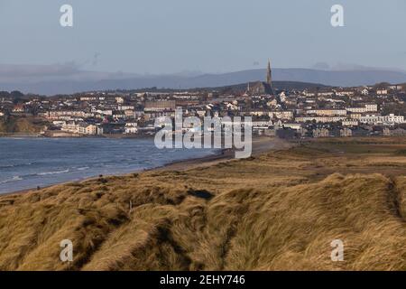 Irischer Strand mit Stadt im Hintergrund mit katholischer Kirche auf dem Berg. Tramore Naturschutzgebiet. Waterford. Irland. Horizontales Format Stockfoto