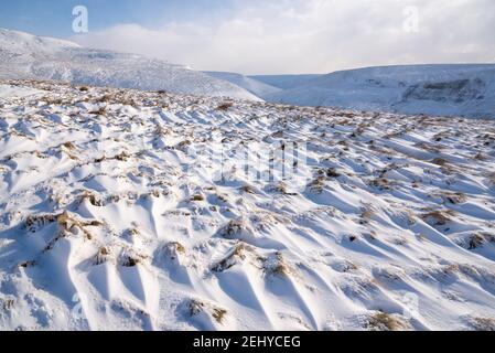 Muster von treibendem Schnee auf dem freiliegenden Pennine Moorland oberhalb von Glossop, Derbyshire, England. Stockfoto