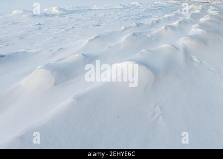 Muster im Schnee auf dem Eis an der Grand Traverse Bay in der Nähe von Traverse City, Michigan. Stockfoto