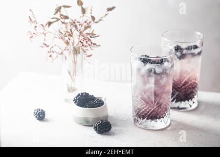Erfrischende Blackberry Lemonade mit Eis in Kristallgläsern auf weißem Hintergrund Stockfoto