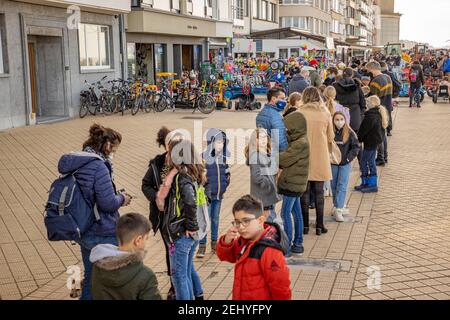 Abbildung Bild zeigt Leute Schlange, um ein Tretauto (trapauto - go-cart - cuistax) auf der Promenade (Ufermauer - zeedijk), bei sonnigem Wetter zu mieten Stockfoto