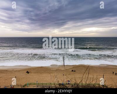 Bournemouth, Großbritannien. Februar 2021, 20th. Bournemouth, Großbritannien. Samstag, 20. Februar 2021. Ein paar Leute sind immer noch am Strand, trotz des bewölkten und windigen Wetters am Bournemouth Beach. Kredit: Thomas Faull/Alamy Live Nachrichten Stockfoto