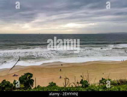 Bournemouth, Großbritannien. Februar 2021, 20th. Bournemouth, Großbritannien. Samstag, 20. Februar 2021. Ein paar Leute sind immer noch am Strand, trotz des bewölkten und windigen Wetters am Bournemouth Beach. Kredit: Thomas Faull/Alamy Live Nachrichten Stockfoto