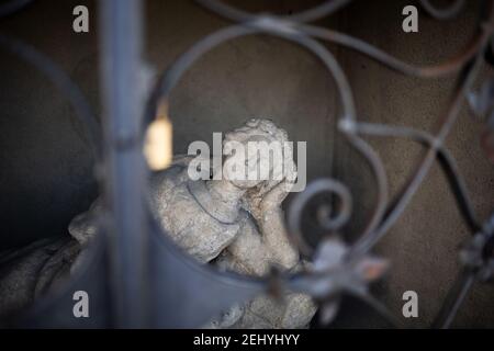 Statue und Skulptur von Frau, Frau und Mädchen ist hinter den Bars versteckt. Figurine kontempliert und träumt mit geschlossenen Augen. Sehr geringer Fokus. Stockfoto