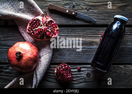 Granatapfel und Flaschen Essenz oder Tinktur auf rustikalen Holztisch Stockfoto