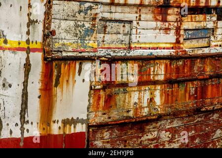 Rostendes Holzfischboot zeigt Farbschichten und Abnutzung in der Küstenhafenlage . Camaret-sur-Mer, Finistere, Frankreich Stockfoto