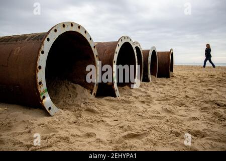 Große Stahlrohre, die zum Pumpen von ausgebaggertem Sand verwendet werden, um den Strand aufzubauen, der die Küste vor Erosion am Strand am Fisherman’s Walk in Southbo schützt Stockfoto