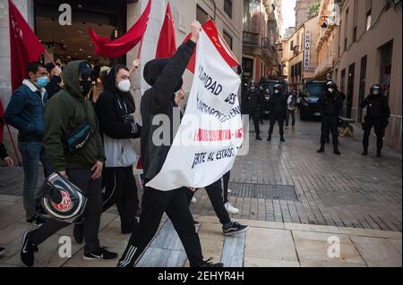 Malaga, Spanien. Februar 2021, 20th. Protestierende halten ein riesiges Banner, während sie während der Demonstration entlang der Marques de Larios Straße marschieren. Der Rapper Pablo Hasel wurde wegen der Verherrlichung des Terrorismus und der Beleidigung der spanischen Krone und der staatlichen Institutionen durch seine Lieder und Tweets verurteilt. Nach seiner Inhaftierung in den letzten Tagen sind in mehreren Städten heftige Unruhen ausgebrochen, als Reaktion auf die Meinungsfreiheit. Kredit: SOPA Images Limited/Alamy Live Nachrichten Stockfoto