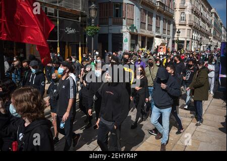 Malaga, Spanien. Februar 2021, 20th. Eine Gruppe von Protestierenden marschiert während der Demonstration entlang der Marques de Larios Straße. Der Rapper Pablo Hasel wurde wegen der Verherrlichung des Terrorismus und der Beleidigung der spanischen Krone und der staatlichen Institutionen durch seine Lieder und Tweets verurteilt. Nach seiner Inhaftierung in den letzten Tagen sind in mehreren Städten heftige Unruhen ausgebrochen, als Reaktion auf die Meinungsfreiheit. Kredit: SOPA Images Limited/Alamy Live Nachrichten Stockfoto