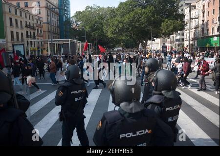 Malaga, Spanien. Februar 2021, 20th. Demonstranten marschieren entlang einer Straße, während Polizeibeamte während der Demonstration Wache stehen. Der Rapper Pablo Hasel wurde wegen der Verherrlichung des Terrorismus und der Beleidigung der spanischen Krone und der staatlichen Institutionen durch seine Lieder und Tweets verurteilt. Nach seiner Inhaftierung in den letzten Tagen sind in mehreren Städten heftige Unruhen ausgebrochen, als Reaktion auf die Meinungsfreiheit. Kredit: SOPA Images Limited/Alamy Live Nachrichten Stockfoto
