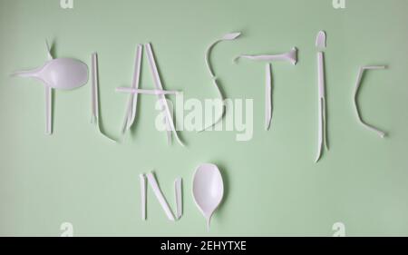 Schriftzug kein Kunststoff aus weißem gebrochenem Kunststoff Löffel auf grünem Hintergrund. Stockfoto
