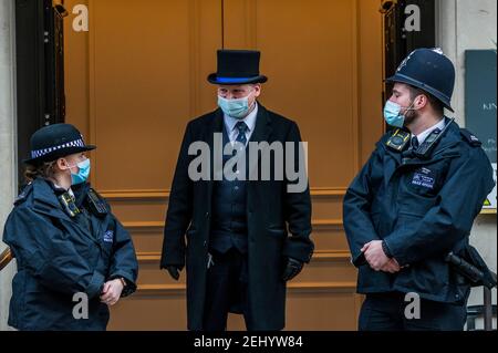 London, Großbritannien. Februar 2021, 20th. Die Polizei und ein Türsteher in einem Hut bewachen die Eingangstür - seine Königliche Hoheit der Herzog von Edinburgh (Prinz Philip) wurde am Dienstagabend im King Edward VII Hospital in Marylebone London eingeliefert. Er wurde offenbar nicht für Covid Gründen trotz National Lockdown 3 weiterhin außerhalb zugelassen. Kredit: Guy Bell/Alamy Live Nachrichten Stockfoto