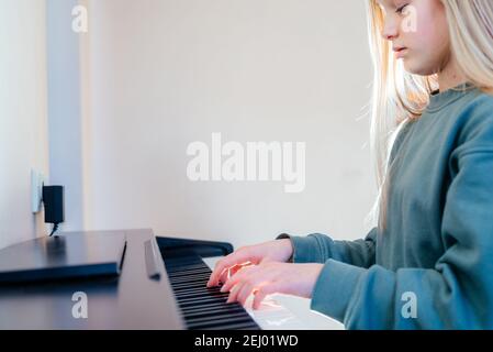 Ein Mädchen im Teenageralter spielt zu Hause E-Piano Stockfoto