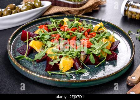 Schmackhafter frischer gesunder Salat mit gekochten Rüben, Microgreen und Orange. Vegetarisches Essen Stockfoto